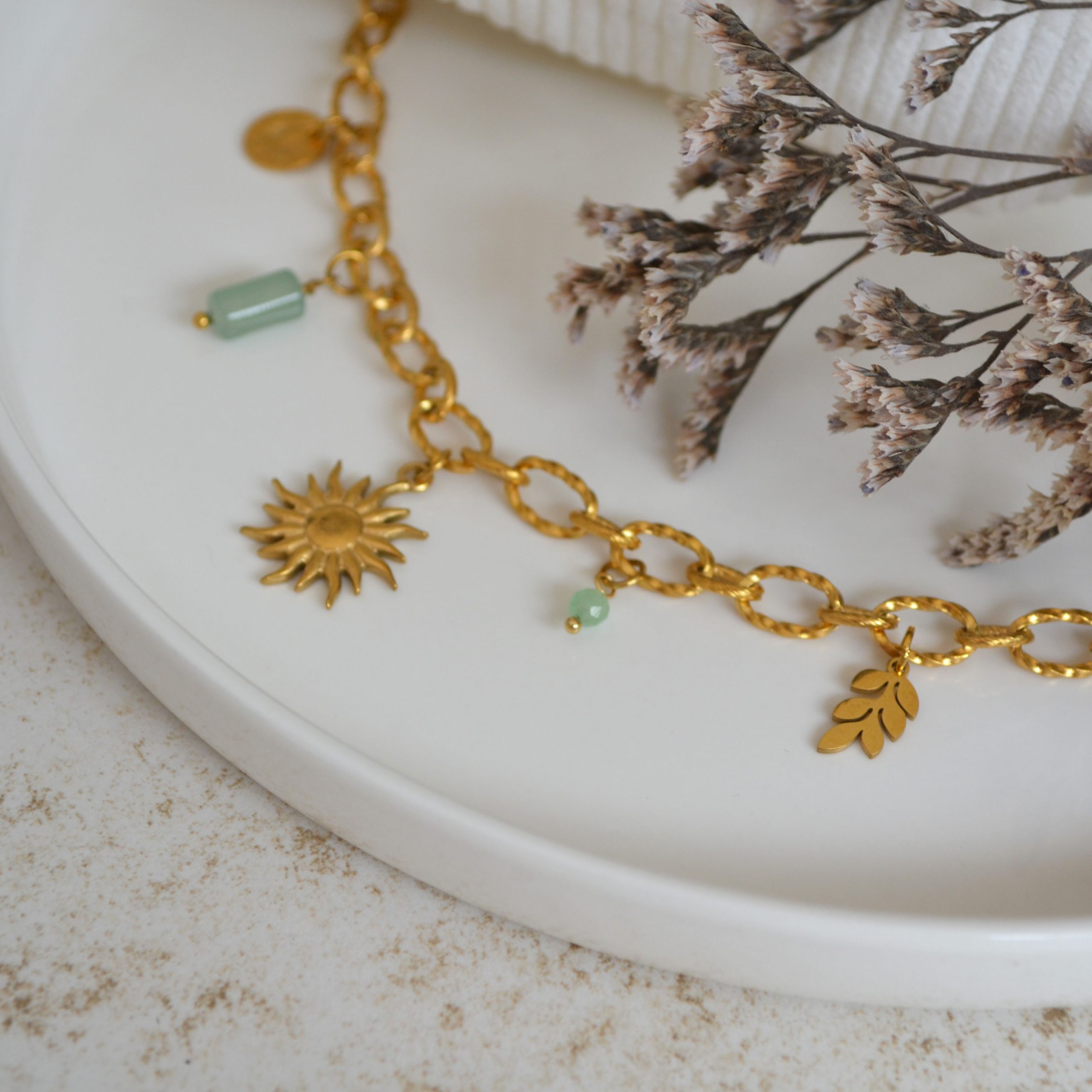Collier en acier inoxydable avec maxi maillons orné de cinq pendentifs dorés et verts pastel esprit printemps fleuri.