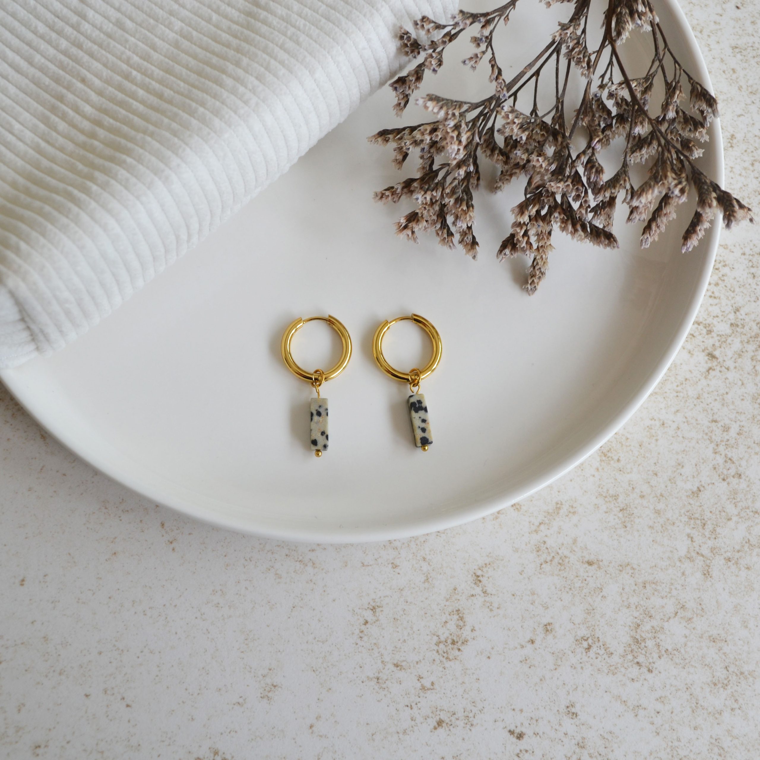 Boucles d'oreilles en acier inoxydable avec mini créoles dorées ornées d'un pendentif en forme de rectangle tachetée.