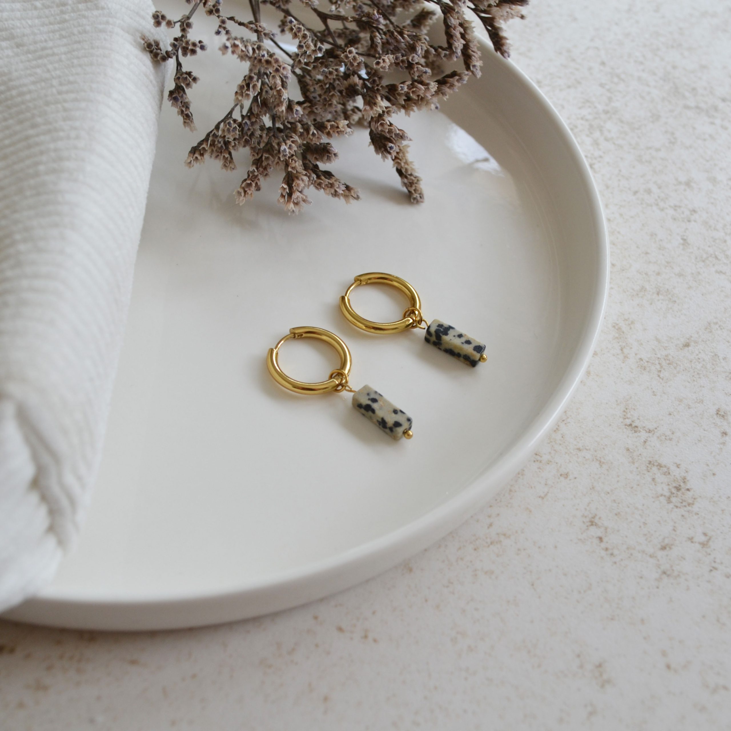 Boucles d'oreilles en acier inoxydable avec mini créoles dorées ornées d'un pendentif en forme de rectangle tachetée.
