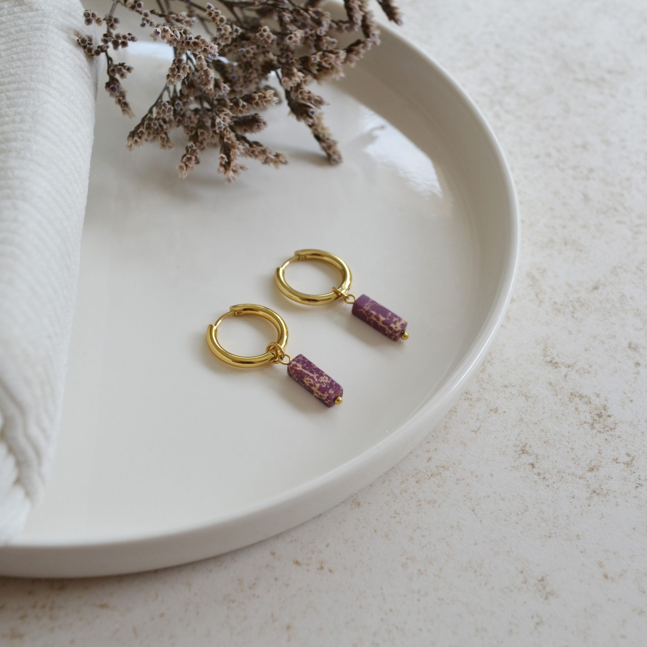 Boucles d'oreilles en acier inoxydable avec mini créoles dorées ornées d'un pendentif en forme de rectangle violet.