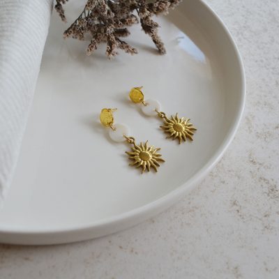 Boucles d'oreilles en acier inoxydable avec puces ornées de pendentifs dorés et blancs esprit vacances à la plage.