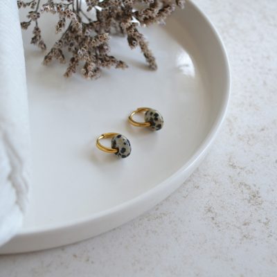 Boucles d'oreilles en acier inoxydable avec mini créoles dorées ornées d'un pendentif en forme de perle tachetée.