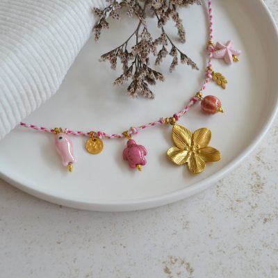 Collier en acier inoxydable avec chaine en cordon rose orné de sept pendentifs dorés et rose esprit floral.