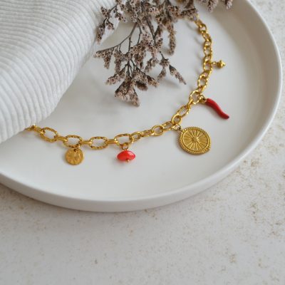 Collier en acier inoxydable avec maxi maillons orné de cinq pendentifs dorés et rouges.