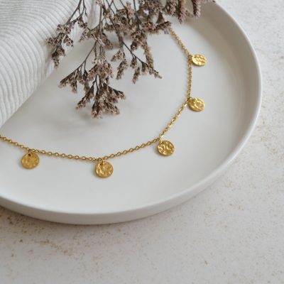 Collier en acier inoxydable avec chaine fine orné de cinq pendentifs ronds dorés à grains esprit élégant.