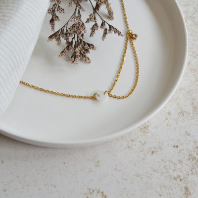 Collier en acier inoxydable avec chaine fine orné de pendentifs dorés et blanc esprit élégant.