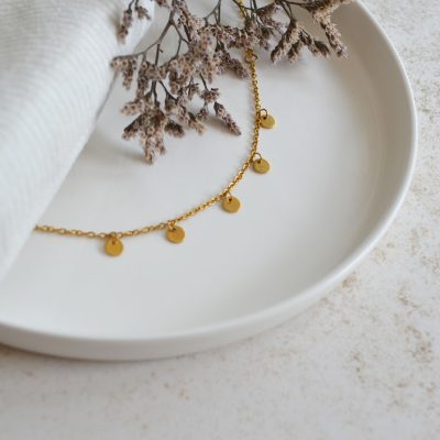 Bracelet en acier inoxydable avec chaine fine orné de cinq petits pendentifs ronds dorés esprit élégant.