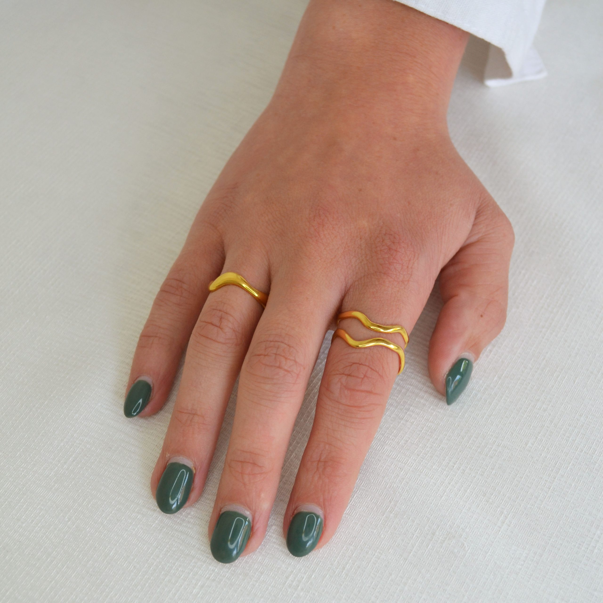 Bague en acier inoxydable dorée en forme de vague fine.