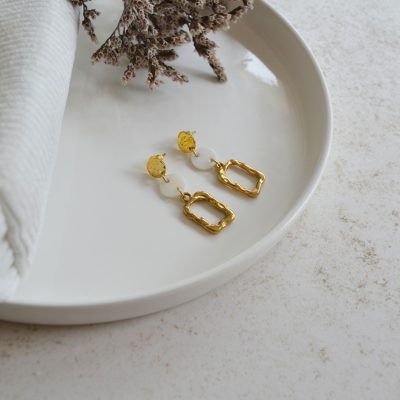 Boucles d'oreilles en acier inoxydable avec puces ornées de pendentifs dorés et blancs esprit élégant.