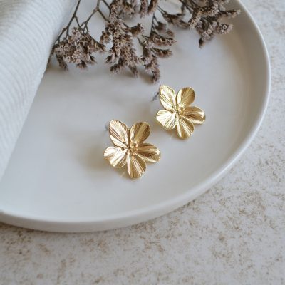 Boucles d'oreilles en acier inoxydable avec puces en fleurs dorées.